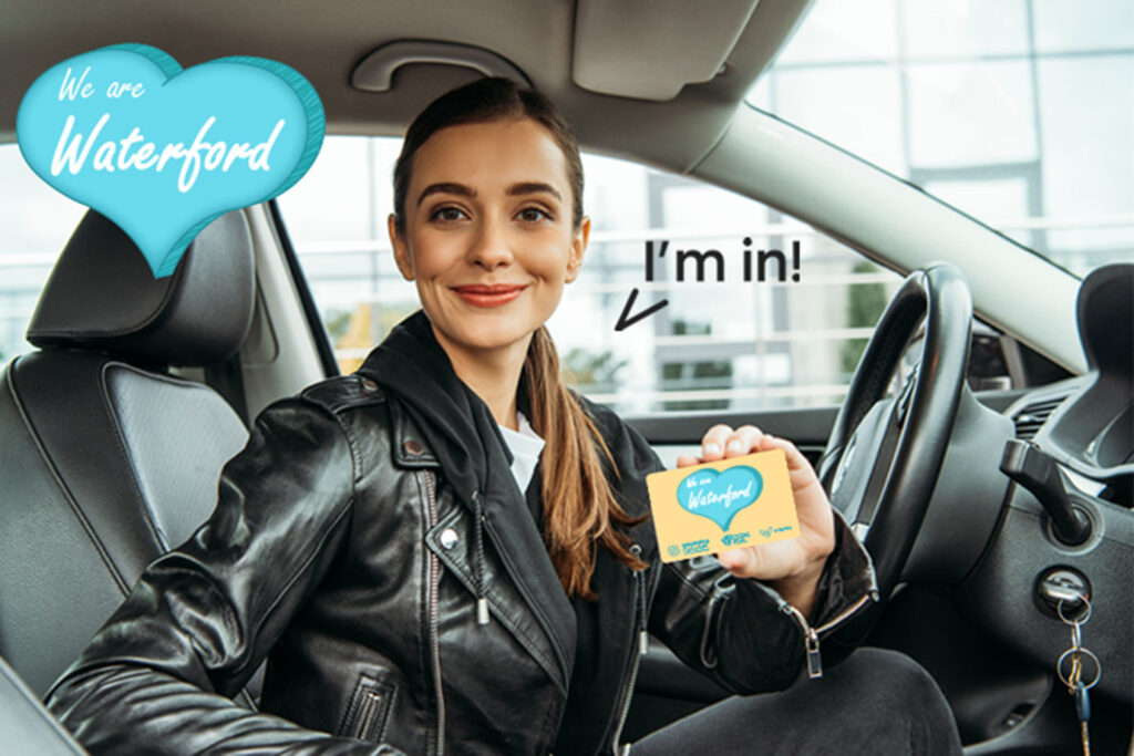 Young Woman in Car holding the We Are Waterford card